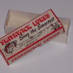 This box came out after the Top-N-Bottom box which was 4 1/2' long. When they started making the Devels Horse lures they needed a longer box. They used this box up to about 1957 and then the size was changed. They went to a box the same width and length but only 1" high. They used this 1" high box for the Devels series until about 1962 and then used it for the Devils series to about 1963. It was replaced by the one peice cardboard box with the hard plastic top.