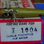 The original number on the Devels Toothpick was ... I-1000.. It then changed to the C-1000.
This is one of the earliest Toothpicks I have seen. It is stamped Devels Toothpick. It is longer than the Toothpicks in later years. The later ones are 2 3/4" long. This one is 3 1/8" long. It is in the color # 4 Green Minnow. The hardware is different than the later ones. It does not have a ball weight. The hooks are different sizes. This is what I call a version 1 Toothpick