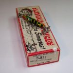 S-300 Race Horse Version 1.
This lure is stamped "Race Horse". The early Race Horse lures were stamped this way and had a large ball weight on the front. In later years they were stamped "Devils Horse Race Horse" and had the big ball weight on the front and a small ball weight on the rear. It comes in color new #11 Dragon Fly which came out in 1963. It also comes with the 2 piece cardboard box stamped Devils-Race-Horse S-311. Both the lure and box are in excellent condition. The Race Horse first appears in the 1963 color chart. All of this indicates that this combo is from 1963... one of the first years production of the Race Horse.